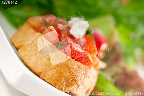 Image of original Italian fresh bruschetta served with fresh salad and ve