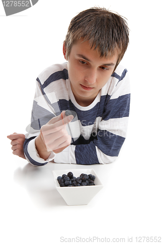 Image of Boy inspecting blueberry