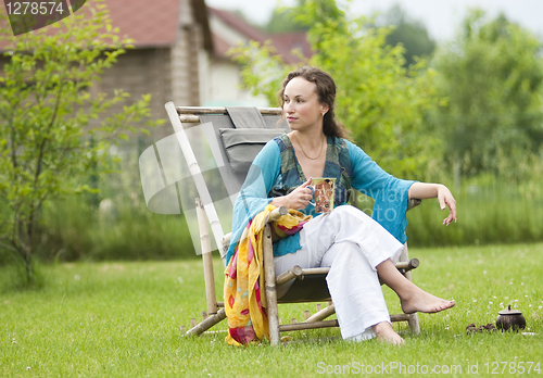 Image of Young woman relaxing on nature