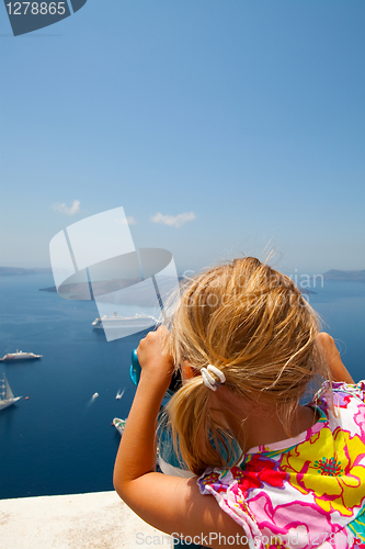 Image of Girl looking with binoculars in Thira, Santorini, Greece