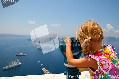 Image of Girl looking with binoculars in Thira, Santorini, Greece