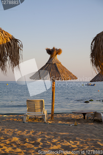 Image of beach with palms umbrella and chairs
