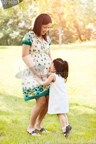 Image of Girl kissing pregnant mother