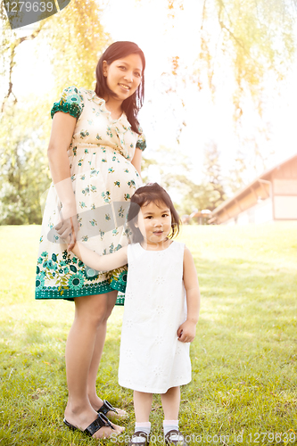 Image of Pregnant Asian mother and her daughter