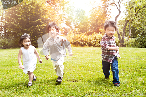 Image of Asian kids running in park