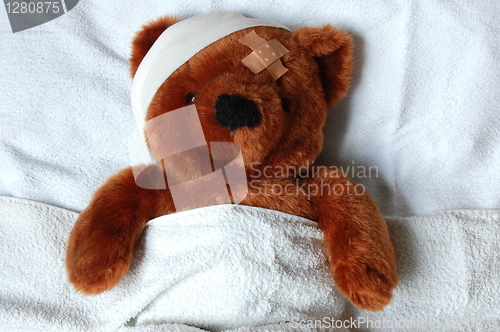 Image of sick teddy with injury in bed