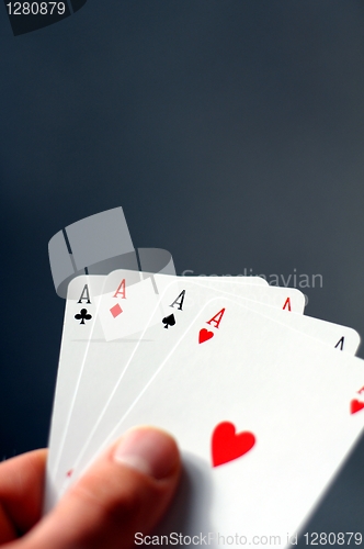 Image of hand holding four aces