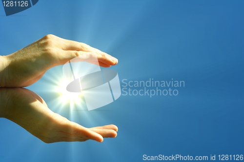 Image of hand sun and blue sky