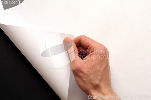 Image of hand turning paper
