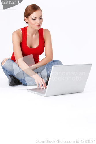 Image of Cute female sitting and using a laptop