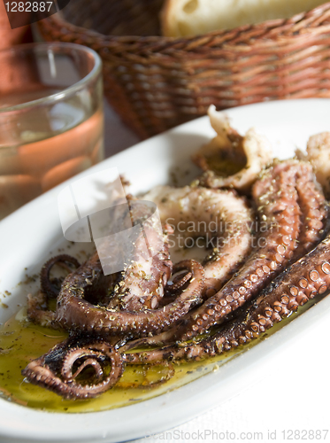 Image of marinated octopus with house wine Greek Island taverna specialty