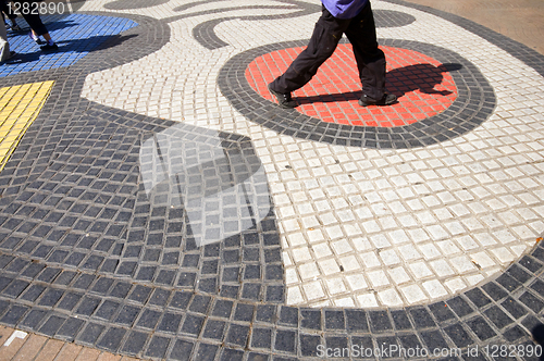 Image of people walking tile mosaic art work on La Rambla Barcelona Spain