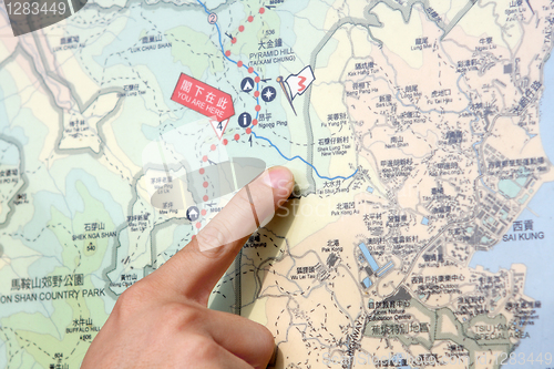 Image of Close up of a hand pointing out location on the map. 