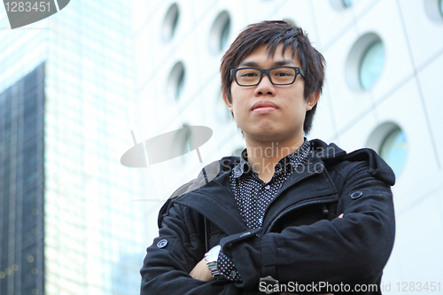 Image of asian man stand in front of building