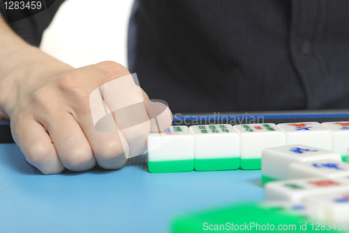 Image of Chinese man play Mahjong, traditional China gamble. 