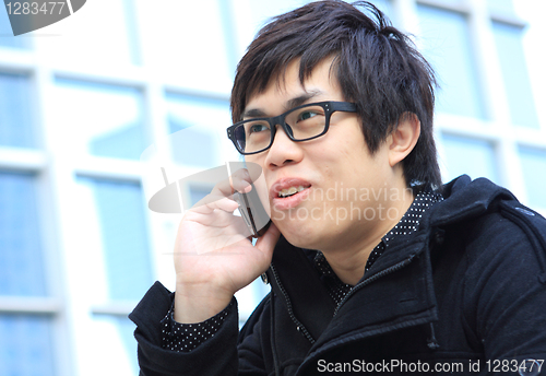Image of Asian Business man using a Cell Phone