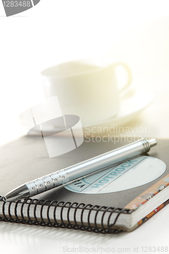 Image of Pen on a white paper with cup of coffee