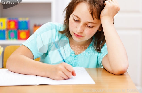 Image of Schoolgirl writing boring homework