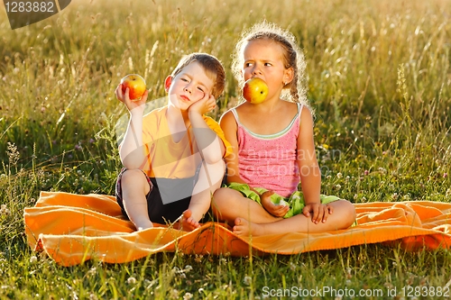 Image of Little girl and boy eating apple