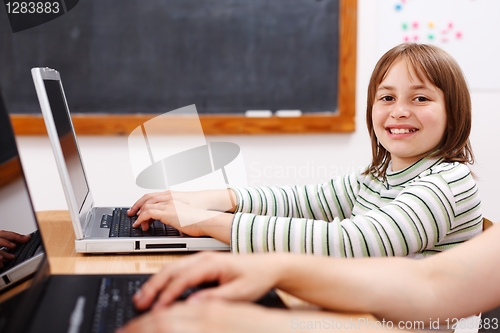 Image of Cheerful schoolgirl with laptop
