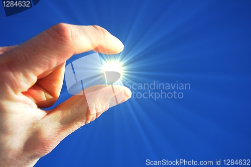 Image of hand fingers sky and sun