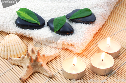 Image of foldet white bath towel and zen stones