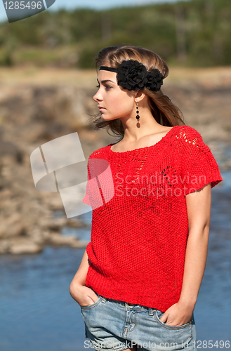 Image of Beautiful girl in a red sweater and denim shorts