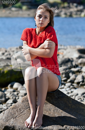 Image of girl badly frozen sitting on a rock
