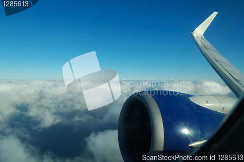 Image of Wing of Boeing 737 jet plane flying over clouds