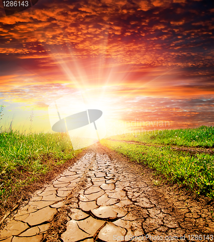 Image of sunset over cracked rural road