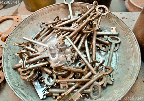 Image of a lot of old brass key on an old plate