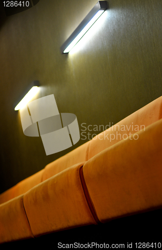 Image of Beige couch and lights in a room with dark green walls