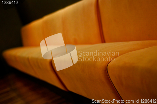 Image of beige sofa in the room with dark green walls close up