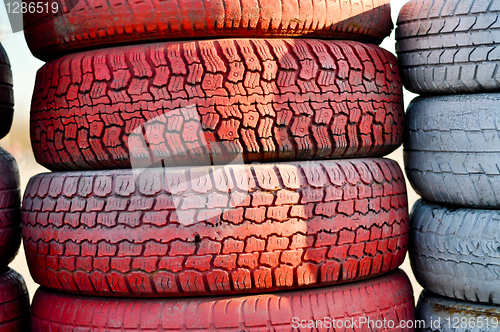 Image of close up of racetrack fence of  red and white old tires