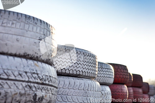 Image of close up of racetrack fence of  red and white old tires