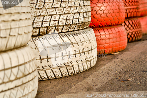 Image of close up of racetrack fence of white and red of old tires