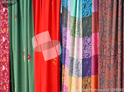 Image of colorful patterned fabrics hanging in a row