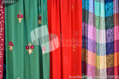 Image of colorful patterned fabrics hanging in a row