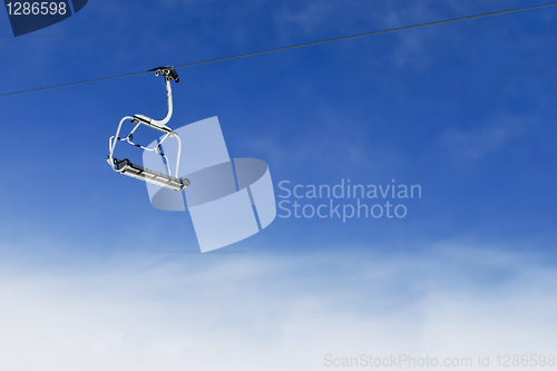 Image of Ski lift chair on bright blue sky
