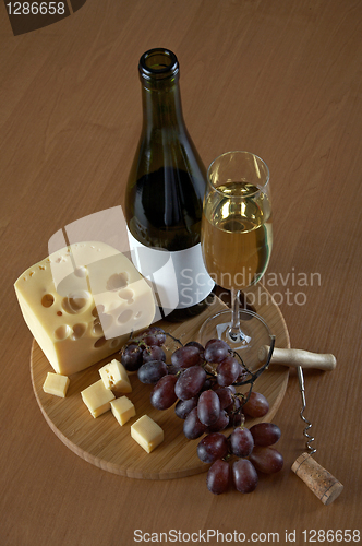 Image of Bottle and glass of white wine with cheese