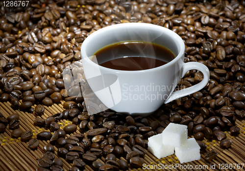 Image of Coffee cup with sugar on roasted beans