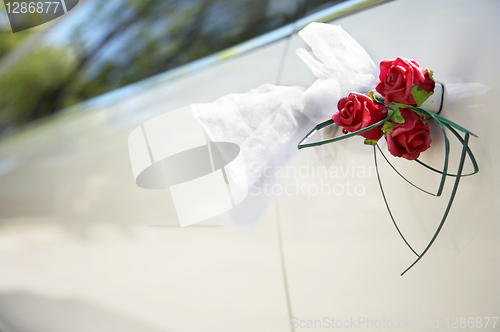 Image of Door of white wedding car with flower and white bow