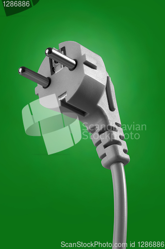 Image of electrical cable with plug on green background