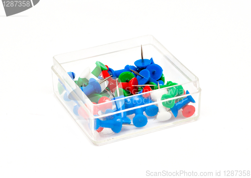 Image of colorful plastic push pins in a box isolated on white