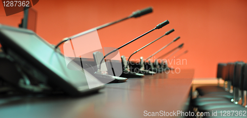 Image of Conference table, microphones and office chairs close-up