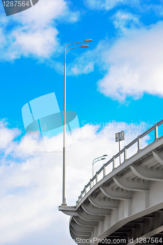 Image of lamppost at the overpass on background of blue sky with clouds