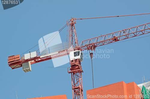 Image of Construction crane at the construction site, on a cloudless sky 