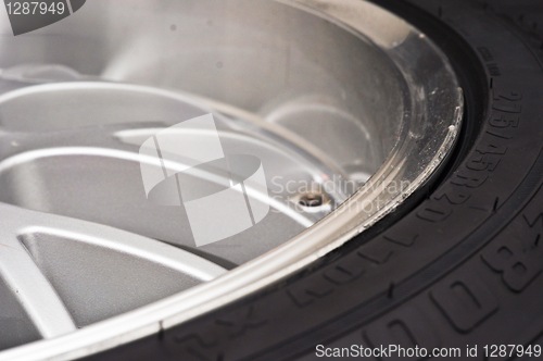 Image of low-profile car wheel on a black background close up