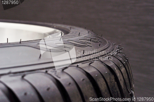 Image of low-profile car wheel on a black background close up