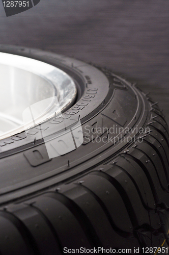 Image of low-profile car wheel on a black background close up